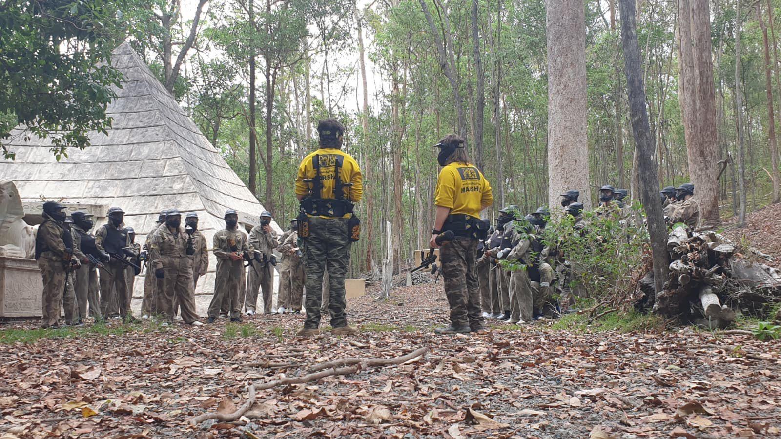 Delta Force marshals leading a player briefing in a woodland game zone